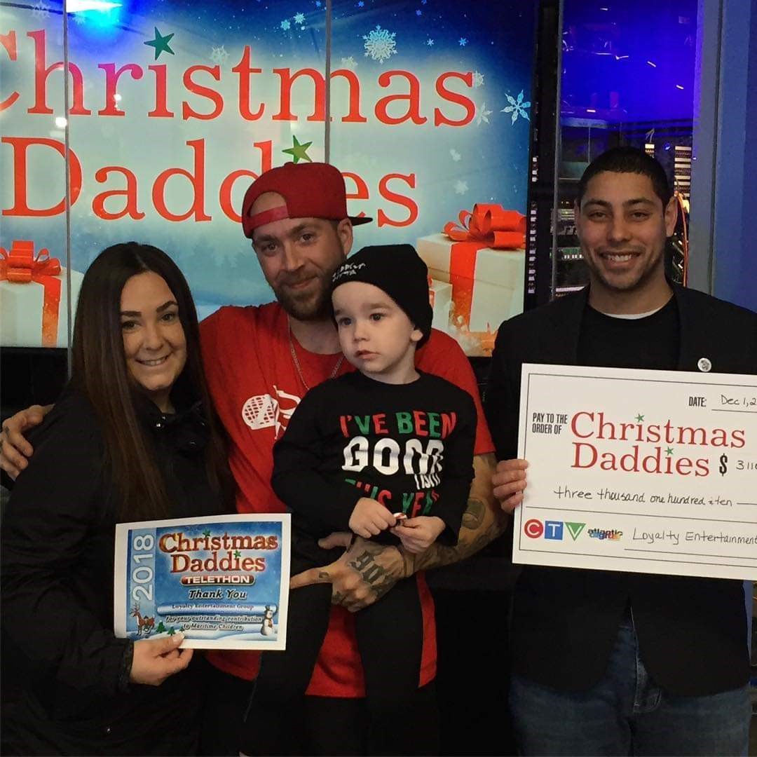 Michael and his friends with giant cheque at Christmas Daddies